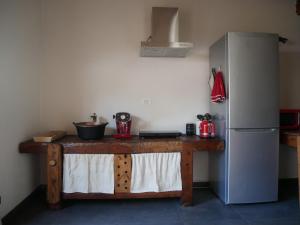 a kitchen with a wooden table and a refrigerator at Villard Guesthouse in Oulx
