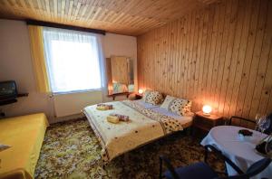 a small bedroom with a bed and a window at Penzion Ivana in Harrachov