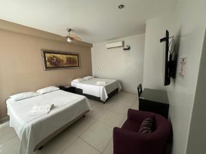 Ένα ή περισσότερα κρεβάτια σε δωμάτιο στο Cacique Hotel