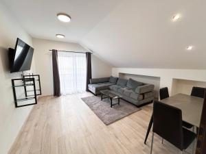 a living room with a couch and a table at Grey Apartment Hlohovec in Hlohovec