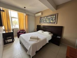 Ένα ή περισσότερα κρεβάτια σε δωμάτιο στο Cacique Hotel