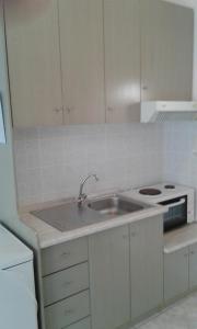 a white kitchen with a sink and a stove at Pansion Argo in Nea Moudania +45 photos