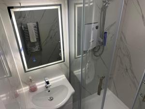 a bathroom with a sink and a shower with a mirror at The Greyfriars Suite by Nestura in Leicester