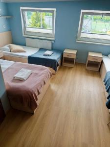 a room with three beds and two windows at Hostel Rakietka in Gdańsk +22 photos