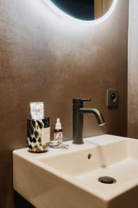 a bathroom sink with a faucet and a mirror at RAIBU GHENT by STAY-C in Ghent +76 photos
