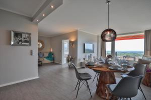 una sala da pranzo e un soggiorno con tavolo e sedie di Best View 25th floor, App 331 a Timmendorfer Strand
