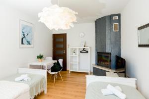 a bedroom with two beds and a fireplace and a chandelier at NaNoc - noclegi obok lubelskich szpitali i centrum Lublina in Lublin