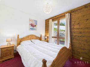 een slaapkamer met een groot bed en een raam bij Appartement 4 Pièces au Centre de la Station, Proche Remontées Mécaniques, Parking et Balcon Est - FR-1-398-521 in La Rosière