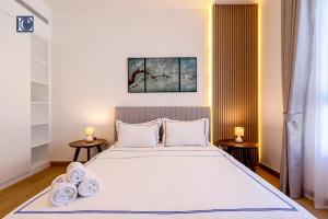 1 Schlafzimmer mit einem großen weißen Bett und 2 Nachttischen in der Unterkunft Luxury Escapes - Breathtaking 1BR with Sea View Port Lamer in Dubai