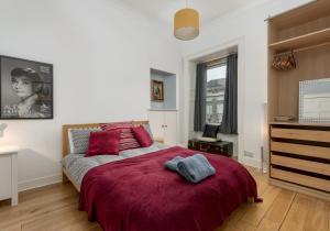 a bedroom with a bed with a red blanket at The Lothian Road Residence in Edinburgh
