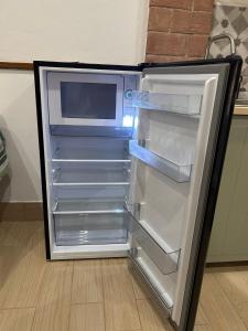 Un refrigerador vacío con la puerta abierta en una cocina. en Il Rifugio nel Borgo, en Lerici