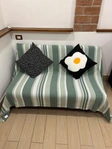 Un sofá verde y blanco con dos almohadas encima. en Il Rifugio nel Borgo, en Lerici