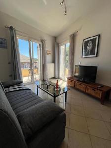 a living room with a couch and a flat screen tv at Litsa's Central Apartments in Agios Rokkos
