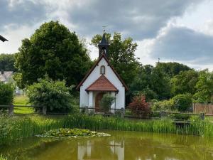 a small chapel with a pond in front of it at Ferienwohnung Cäcilie 