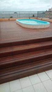 a wooden deck with a swimming pool in a building at Gaivotas Praia Hotel in São Francisco do Sul