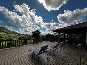 two chairs and a table on a wooden deck at Villa Italia hospedagem in Gramado +158 photos