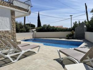 a patio with two chairs and a swimming pool at Villa Orense 5 in Palau-Saverdera