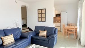 a living room with a blue couch and a table at Villa Orense 5 in Palau-Saverdera