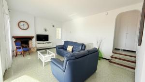 a living room with a blue couch and a tv at Villa Orense 5 in Palau-Saverdera