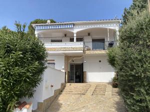 a white house with a gate and a balcony at Villa Orense 5 in Palau-Saverdera