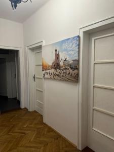 a hallway with two doors and a painting on the wall at City Center Rooms in Kraków