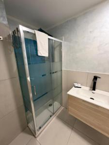 een badkamer met een glazen douche en een wastafel bij Margot Sorrento house in Sorrento