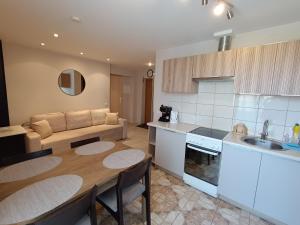 a kitchen and living room with a table and a couch at Audringa in Nida