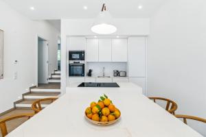 een kom sinaasappels op een witte tafel in een keuken bij The Oceanfront Villa Luz VR114 in Luz