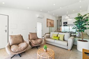 een woonkamer met een bank en twee stoelen bij The Oceanfront Villa Luz VR114 in Luz