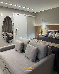 Un dormitorio con una cama y un espejo grande. en Flats Voll29 - By EasyHost, en João Pessoa