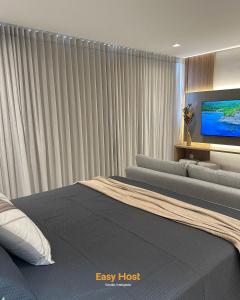Un dormitorio con una cama y un televisor de pantalla plana. en Flats Voll29 - By EasyHost, en João Pessoa 44 fotos más