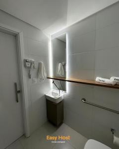 un baño con lavabo y espejo en Flats Voll29 - By EasyHost, en João Pessoa