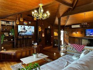 a living room with a couch and a tv at Villa Italia hospedagem in Gramado