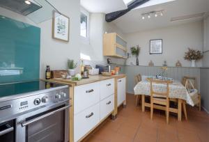 a kitchen with a table and a dining room at Berry Cottage in Croyde