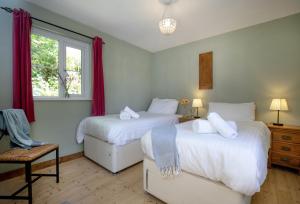 a bedroom with two beds and a window at Berry Cottage in Croyde
