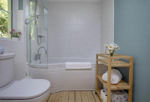 a bathroom with a tub and a toilet and a sink at Berry Cottage in Croyde +36 photos