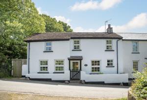 a white house with a gate on a street at Berry Cottage in Croyde