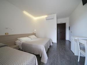 a hotel room with two beds and a sink at LUZIA AGRIRESORT - Piscina Panoramica e vista Mare a Capo Vaticano in Capo Vaticano