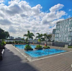 a large swimming pool with palm trees and buildings at HAVEN on the 28th in Manila
