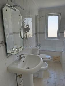a white bathroom with a sink and a toilet at Casa Serradalto in Manteigas