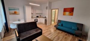 Una sala de estar con un sofá y una cocina. en Marina Apartamenty, en Rozewie