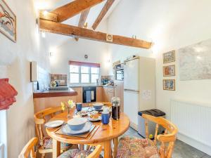 a kitchen with a wooden table and a refrigerator at Hollow Creek Cottage - 28012 in Rockcliffe