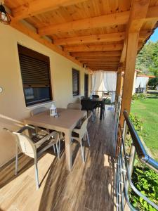 un patio con tavolo, sedie e TV di Bungalows anestis a Toroni