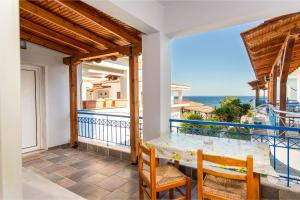 a balcony with a table and chairs and the ocean at Melissa Gold Coast in Psakoudia