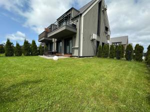 een huis met een groot grasveld ervoor bij Family Studio VAIVORYKSTE in Palanga