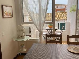 ein Esszimmer mit einem Tisch und einem Fenster in der Unterkunft Apartamento Sant Feliu de Guixols in Sant Feliu de Guixols