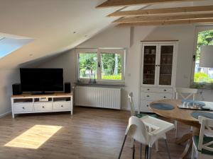 メーネゼーにあるGroße FeWo mit 2 Schlafzimmern in Körbeckeのリビングルーム(テレビ、ダイニングテーブル付)