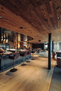 a restaurant with chairs and a bar in a room at Jungbrunn Der Gutzeitort in Tannheim