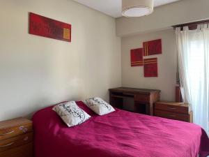 a bedroom with a purple bed with two pillows at A pasos del mar in San Bernardo