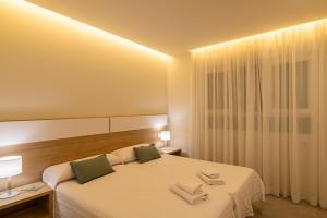 a bedroom with a bed with two towels on it at Apartamento Vidamar 1 in Conil de la Frontera